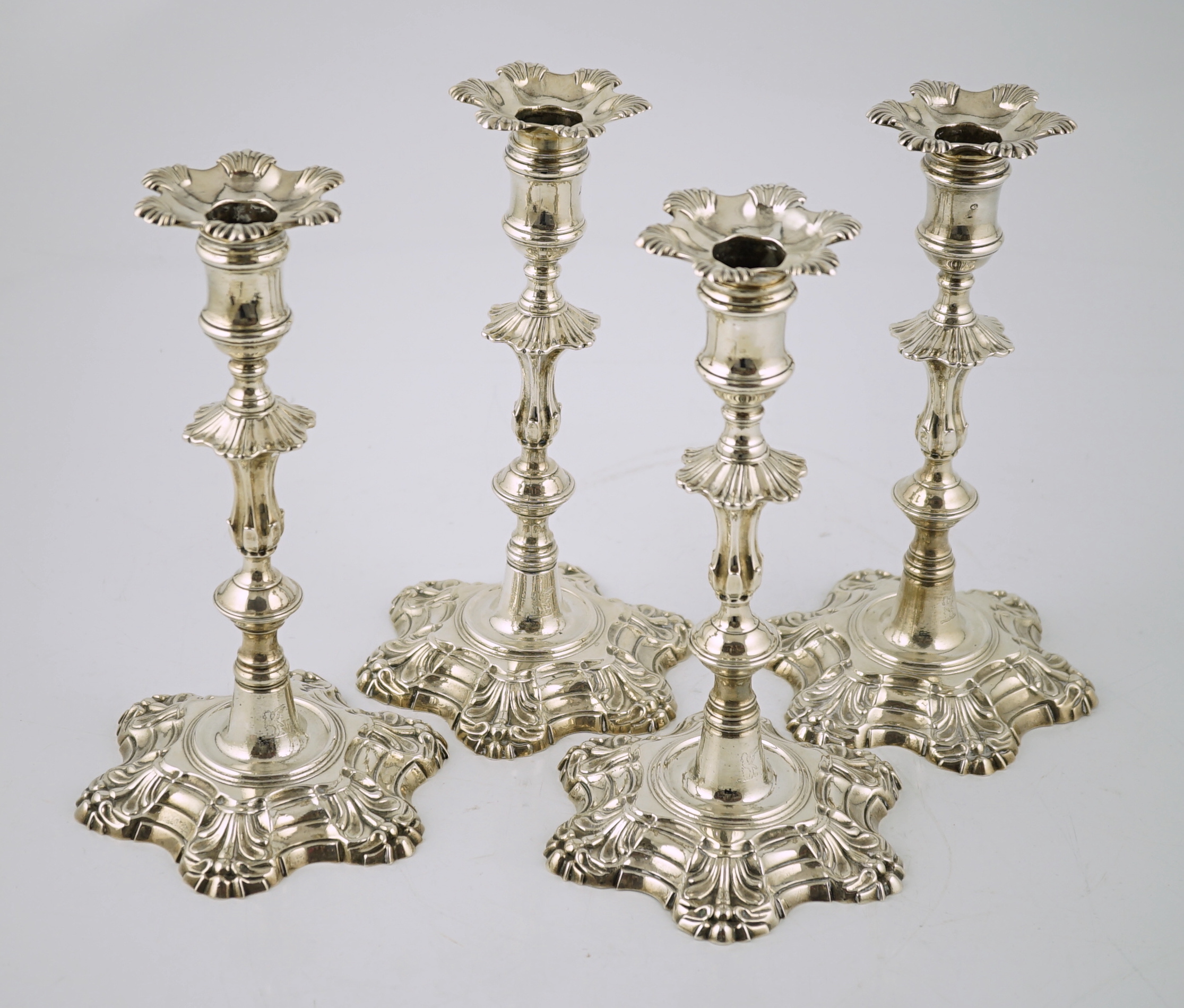 A set of four George II cast silver table candlesticks, by John Cafe